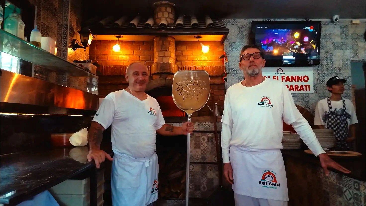 The two owners of Agli Amici Phuket standing by the wood fired pizza oven